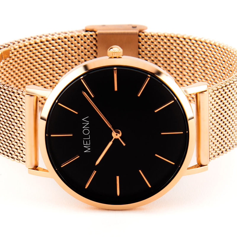 Reloj minimalista de mujer con correa de malla oro rosa y esfera negra de la marca de joyería española Melona. Colección Alma Mesh