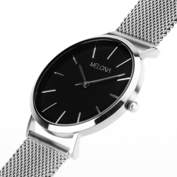 Minimalista reloj de mujer con correa plata de malla y esfera negra de la marca de joyería española Melona. Colección Alma Mesh