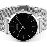 Minimalista reloj de mujer con correa plata de malla y esfera negra de la marca de joyería española Melona. Colección Alma Mesh