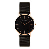 Reloj minimalista de mujer con correa de malla negra y detalles dorados de la marca de joyería española Melona. Colección Alma Mesh