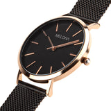 Reloj minimalista de mujer con correa de malla negra y detalles dorados de la marca de joyería española Melona. Colección Alma Mesh