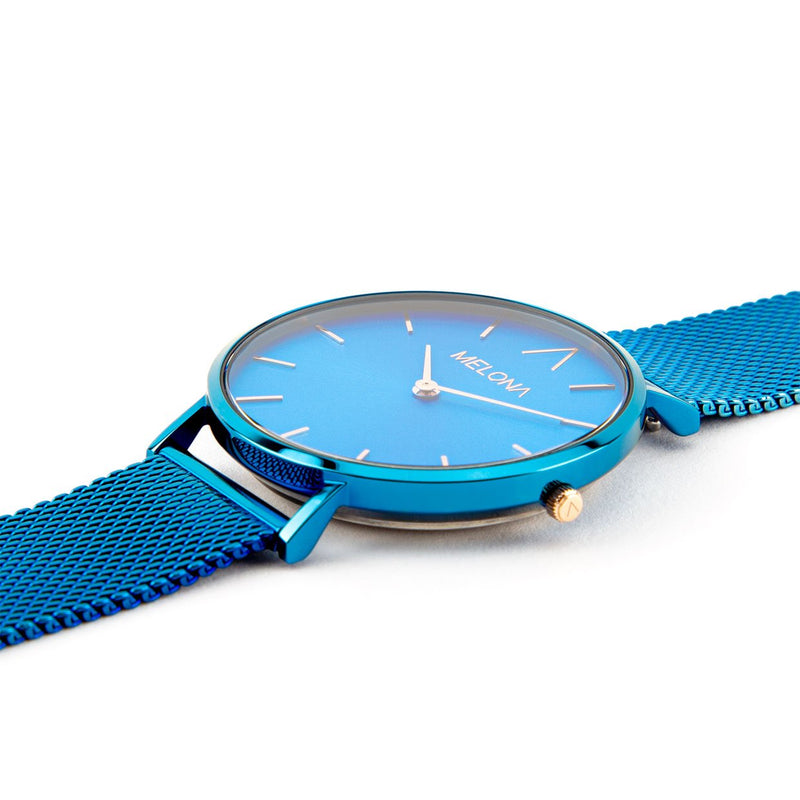 Hermoso reloj de mujer con correa de malla azul y detalles dorados de la marca de joyería española Melona